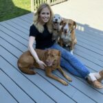 Dr. Danielle Blair sitting on the porch with her dogs
